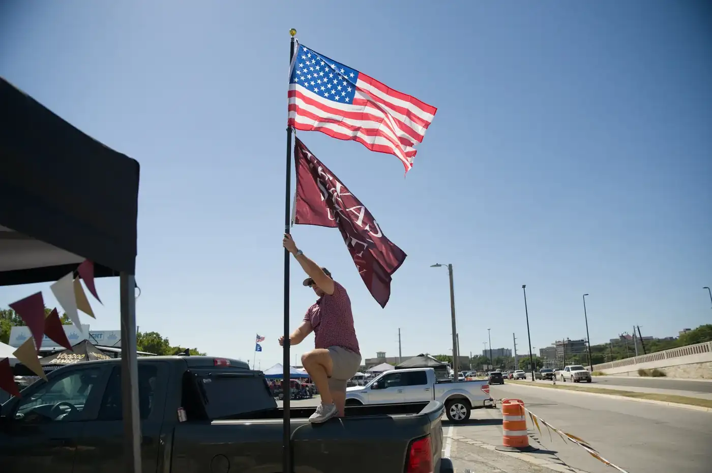 Texas and American flags flying over a Turnkey Tents & Events setup
