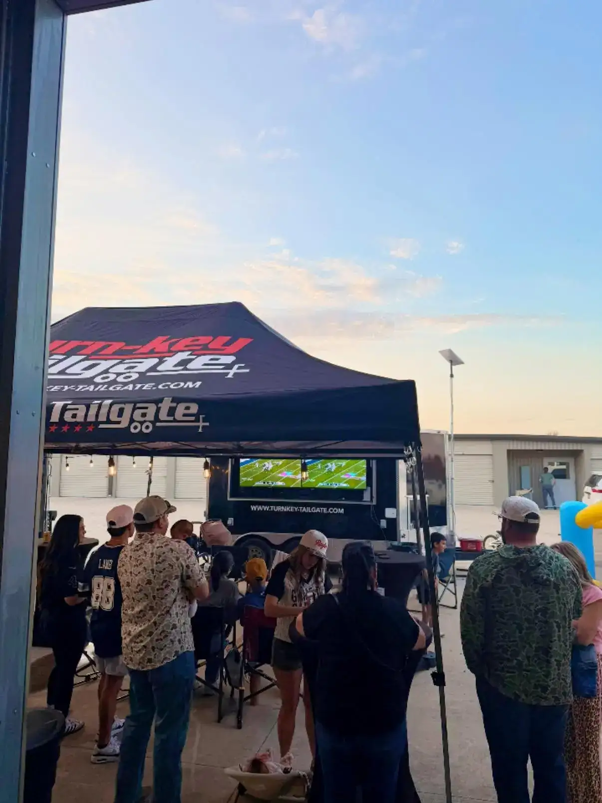 Neighbors watching a game at a tailgate trailer watch party